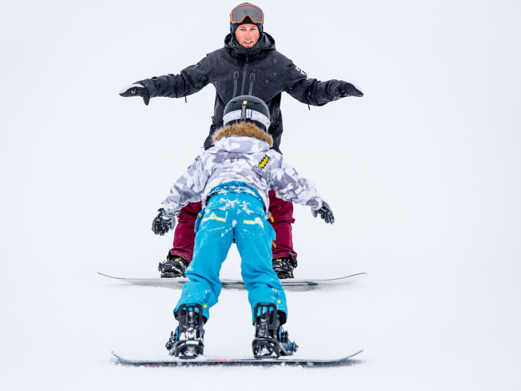 Snowboarder mit Skilehrer