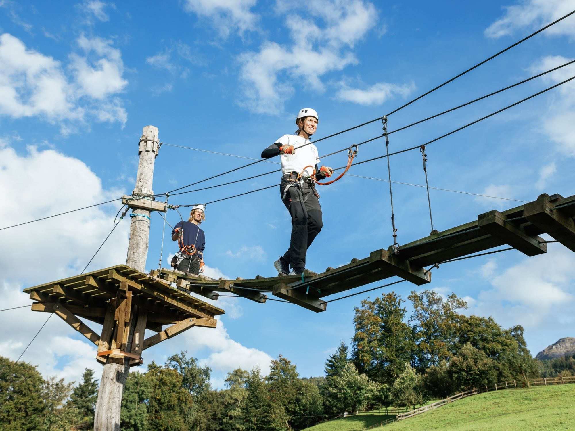 2 Personen gehen über eine Seilbrücke
