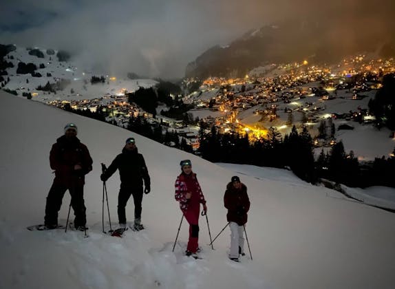 Gruppe Schneeschuhläufer bei Nacht