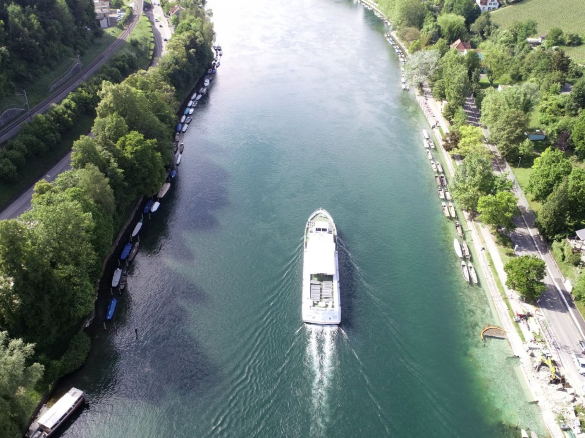 Rheinschifffahrt: Schiff auf dem Rhein bei der Werft mit grüner Uferlandschaft.