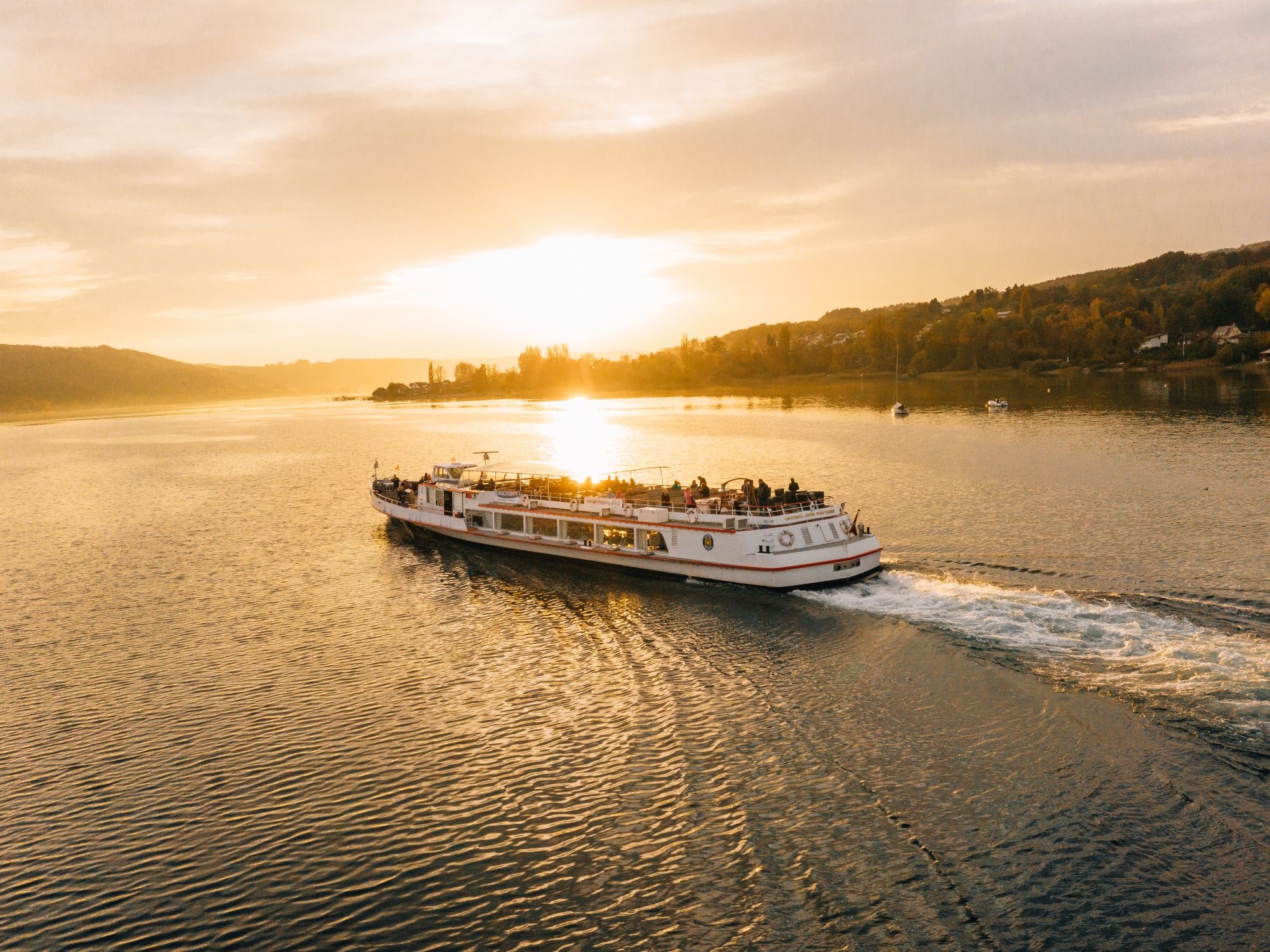 Rheinschifffahrt: Genieße die Fahrt auf dem Rhein mit traumhaftem Sonnenuntergang und schöner Landschaft.