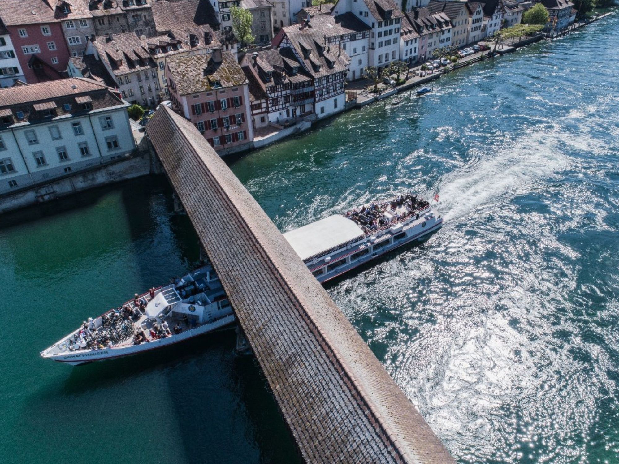 Rheinschifffahrt: Schiff fährt unter die Bruecke in Thurgau mit Blick auf die Stadt.