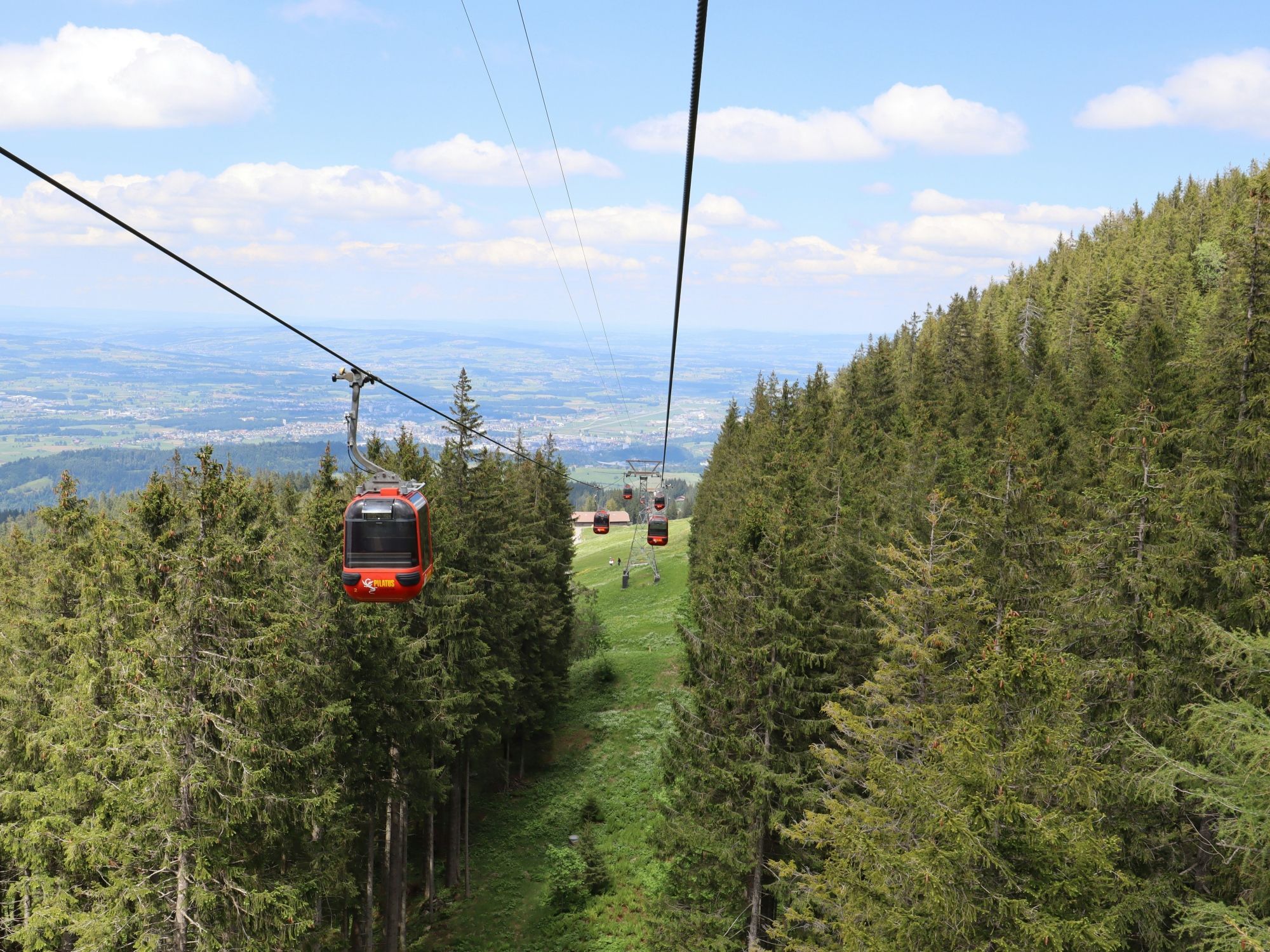 Pilatus: Luftseilbahn mit Blick auf Berge, Wälder und Wanderwege in der Schweiz.