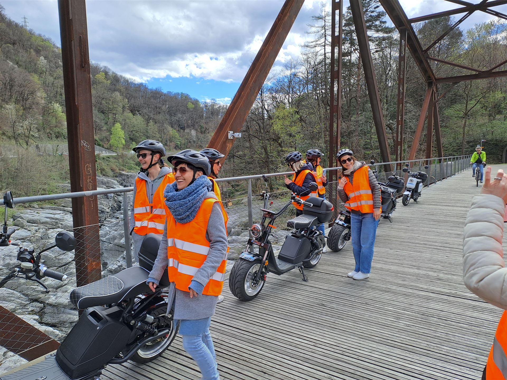 ticinoquad: Grupo con chalecos reflectantes explora la naturaleza en Ascona bajo un clima soleado.