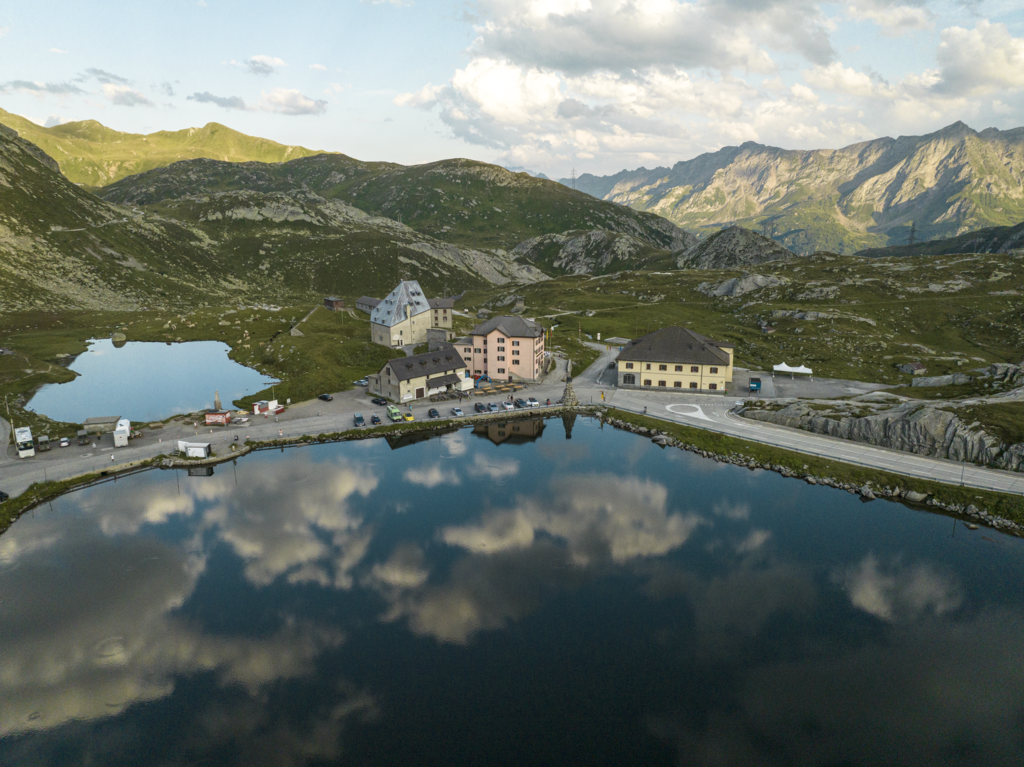 ممر غوتارد: حافلات بريدية ومناظر طبيعية تعكس جمال الجبال والمياه، مثالي لعشاق الطبيعة.