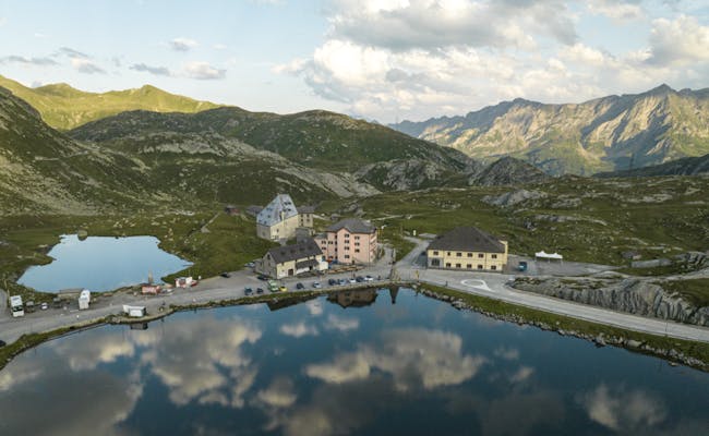 Przełęcz Gotthard: Postauto i odblaskowa scena z górami i wodą, idealna dla miłośników natury.