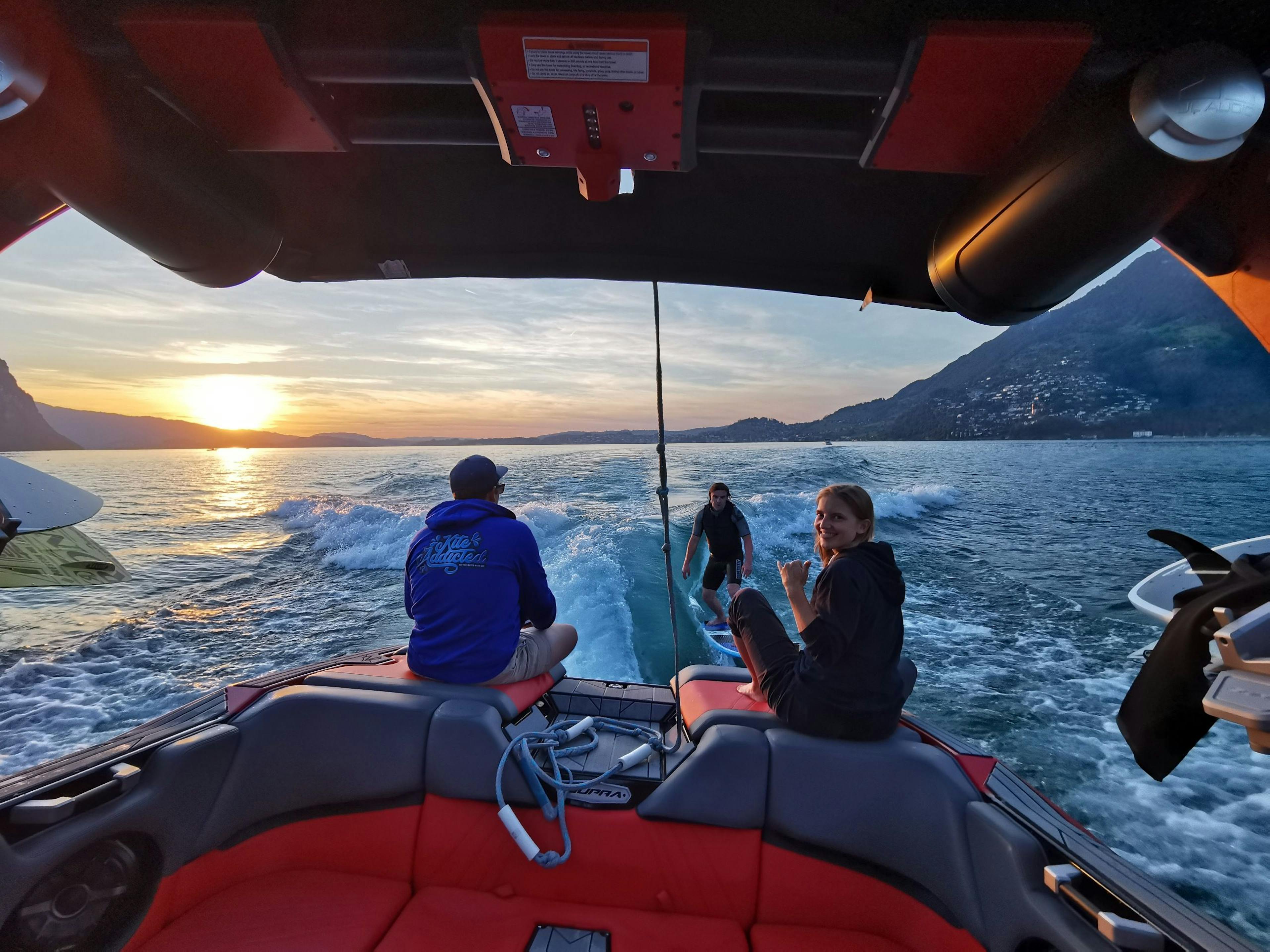 Wakeboarden auf dem Lake Luzern bei Sonnenuntergang mit Freunden. Geniesse den Wassersport im Sommer.