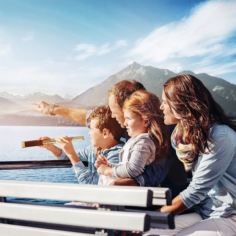 Obitelj na brodu gleda krajolik i vodu. Jesenski praznici 2023.