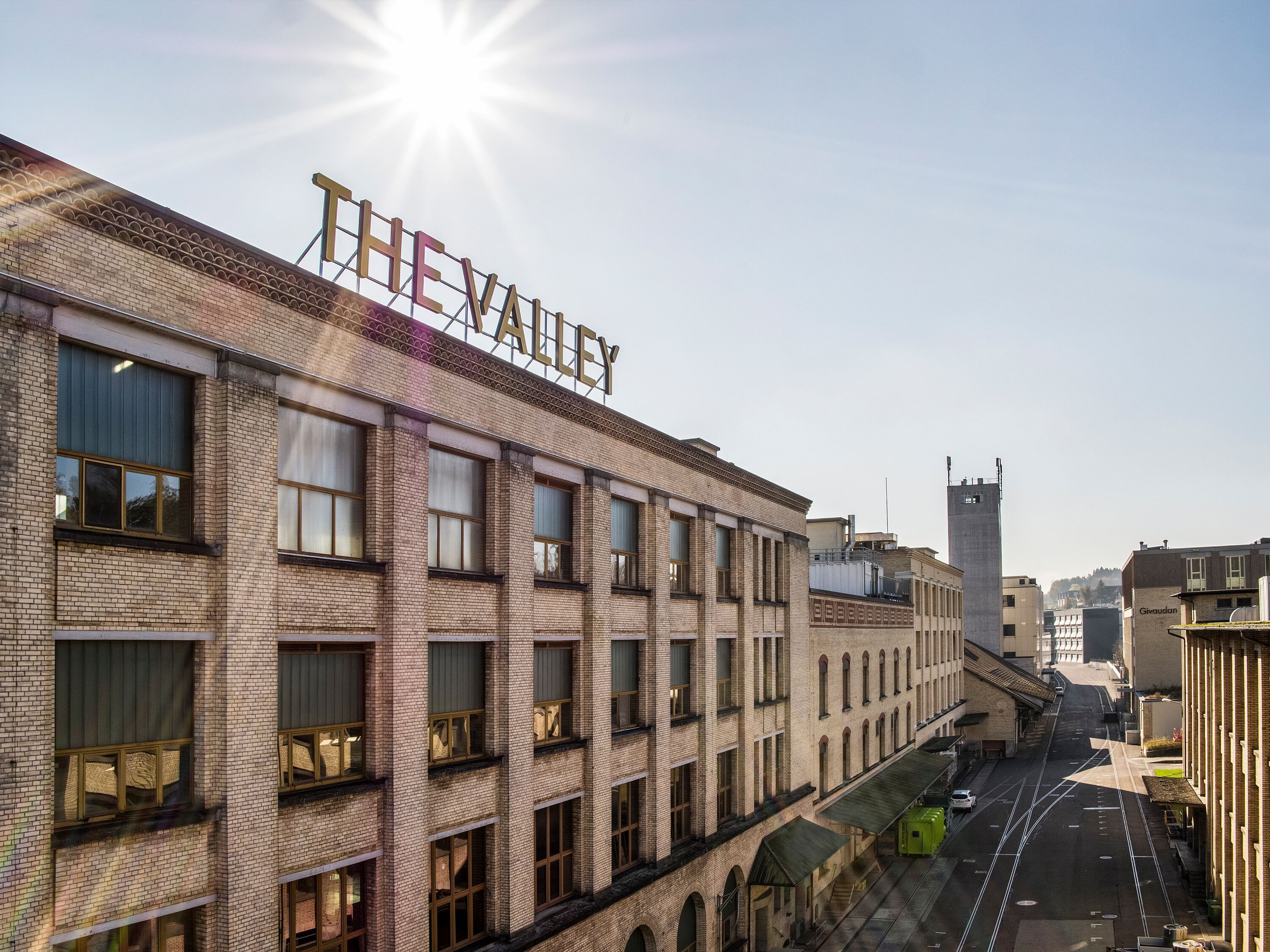 De Vallei: moderne gebouwen in de stad met een gevel van ramen en zonneschijn, ideaal voor een urban lifestyle.