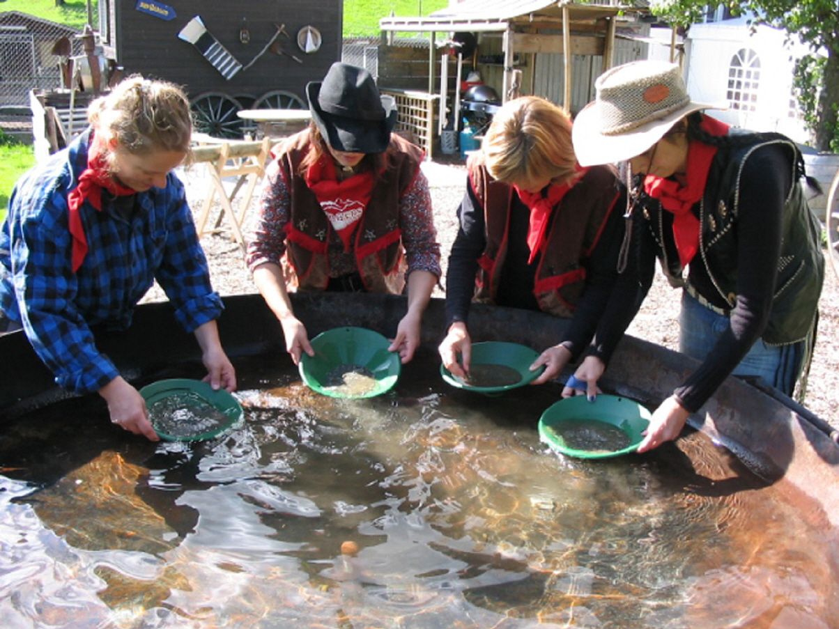 Αναζήτηση χρυσού κατά τη διάρκεια των Western Ολυμπιάδα 2023 με συμμετέχοντες, δοχεία νερού και χρυσά φτυάρια.