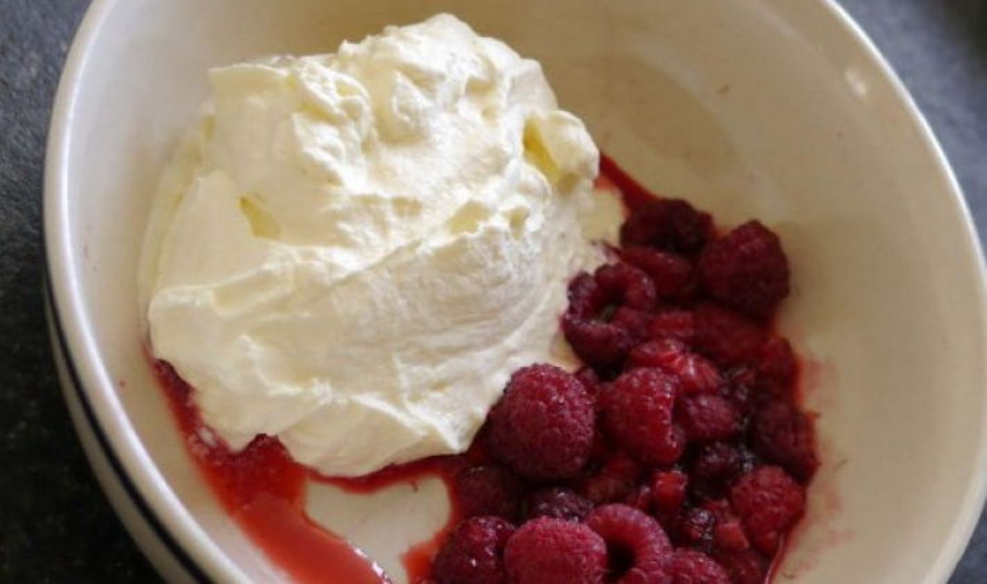 Raspberries with whipped cream in a bowl