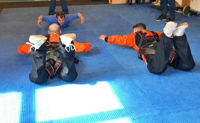 Anweisung zum Skydive: Teilnehmer im Raum in Sprungposition verhalten.