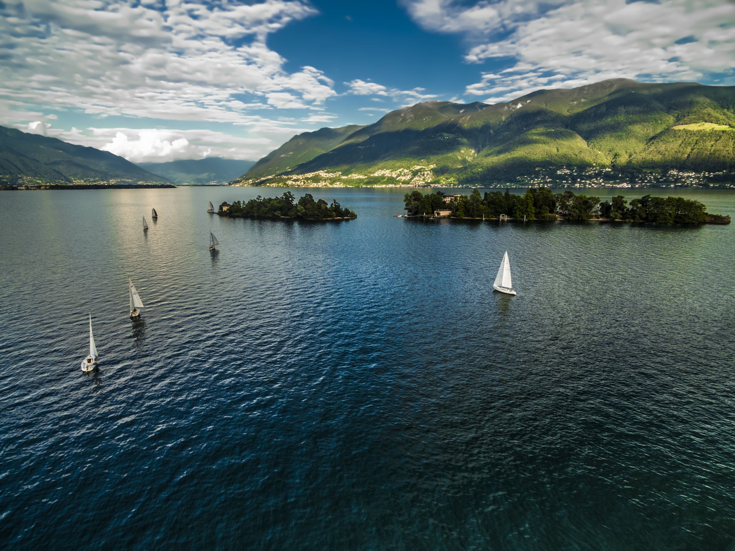 Brissago Islands with sailboats on Lake Maggiore, idyllic landscape in summer in Switzerland.