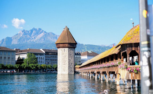 Kapellbrücke v Luzernu s starším věží, modrá obloha.