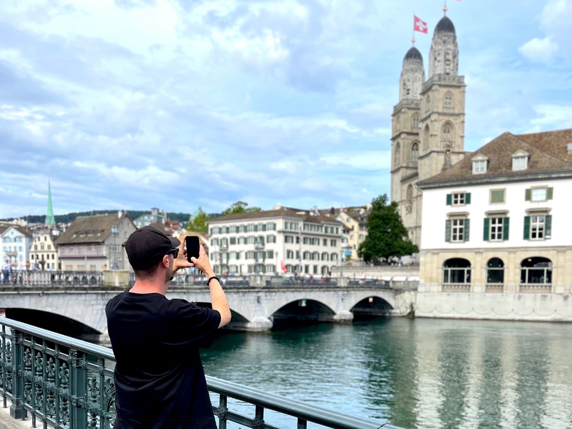 Lago de Zúrich: Hombre fotografía el antiguo puente y el casco antiguo de Zúrich en verano.