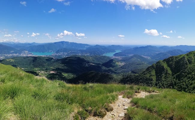 Monte Lema: Widok panoramiczny na malownicze Mehrseetal, zielone góry i niebieskie niebo.