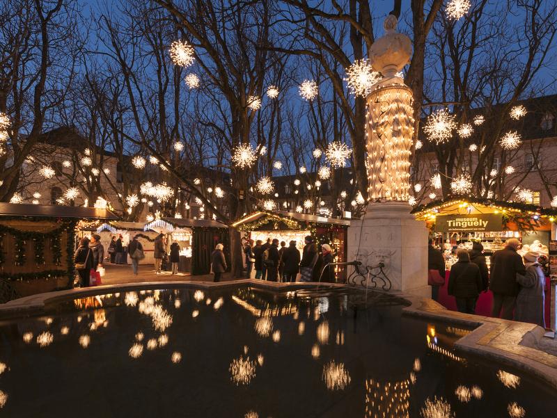 Magia Navideña en Basilea con decoraciones brillantes y visitantes en la plaza del mercado.
