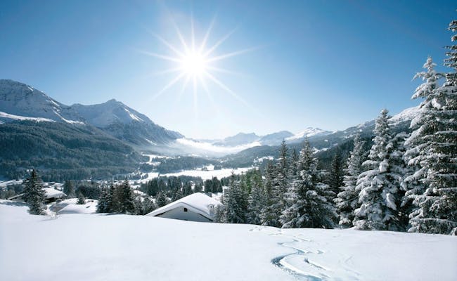Lenzerheide Winter met besneeuwde bergen, een heldere lucht en zonneschijn.