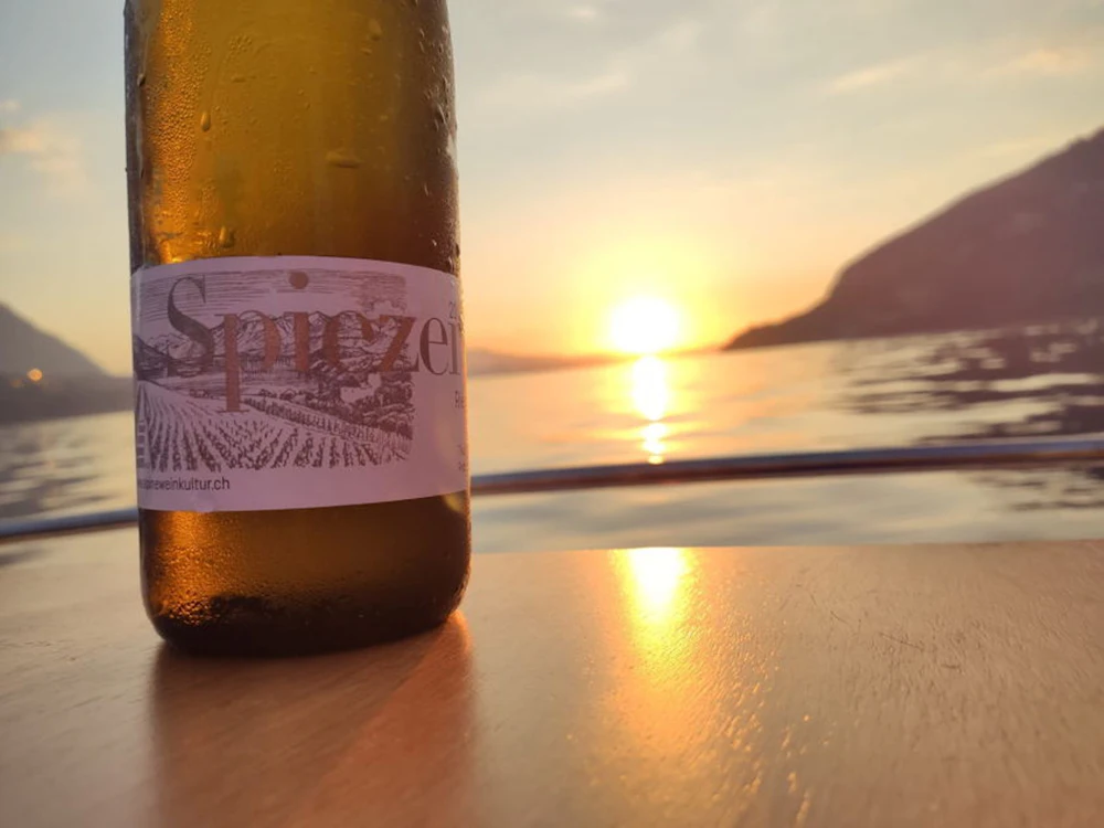 Spitzwein auf Boot mit Käse bei Sonnenuntergang