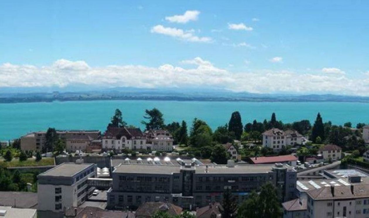 Vista de Peseux con lago y montañas, vista clara, día soleado