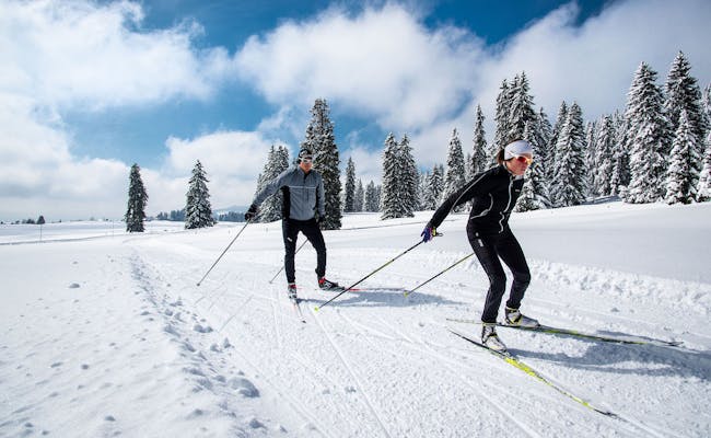Langlauf Sainte Croix dengan pesepak ski sporty di lanskap bersalju dan lingkungan berhutan