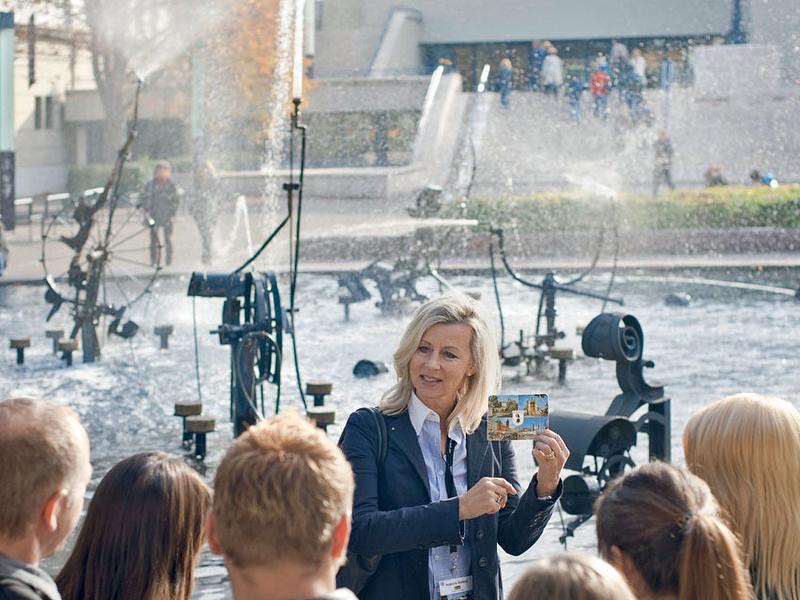 Tinguelyův pramen při prohlídce města v Basileji, průvodkyně ukazuje pohlednici