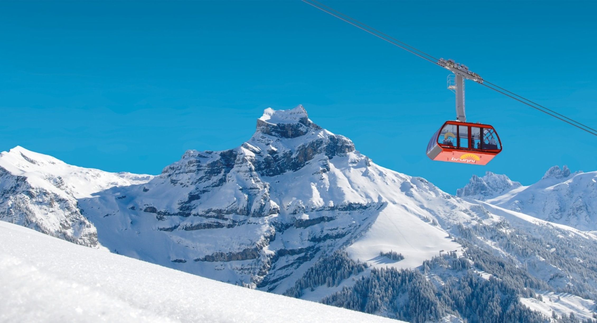 Kereta kabel Engelberg musim sejuk dengan landskap bersalji.