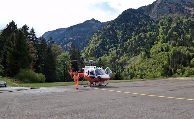 Helikopter in Interlaken, bereit für den Skydive-Tandemsprung vor Bergkulisse.
