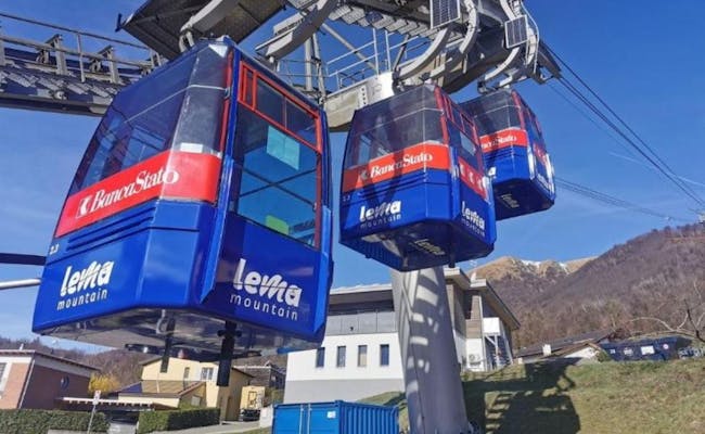 Gondelbahn Monte Lema fährt ins Gebirge. Klare Sicht auf Landschaft und Station.