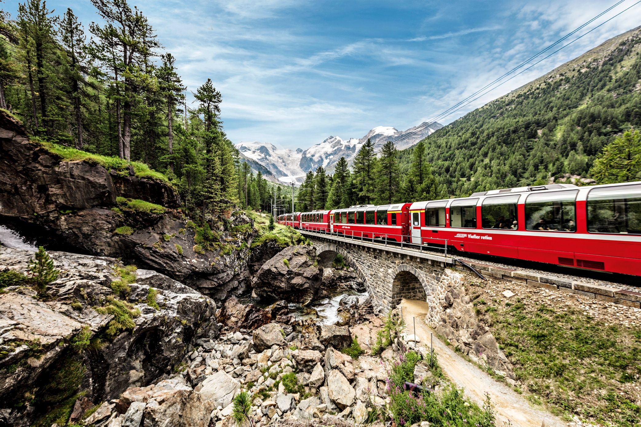 Bernina Express door de natuur bij Morteratsch met bergen op de achtergrond, ideaal voor avontuur en groepsreizen.