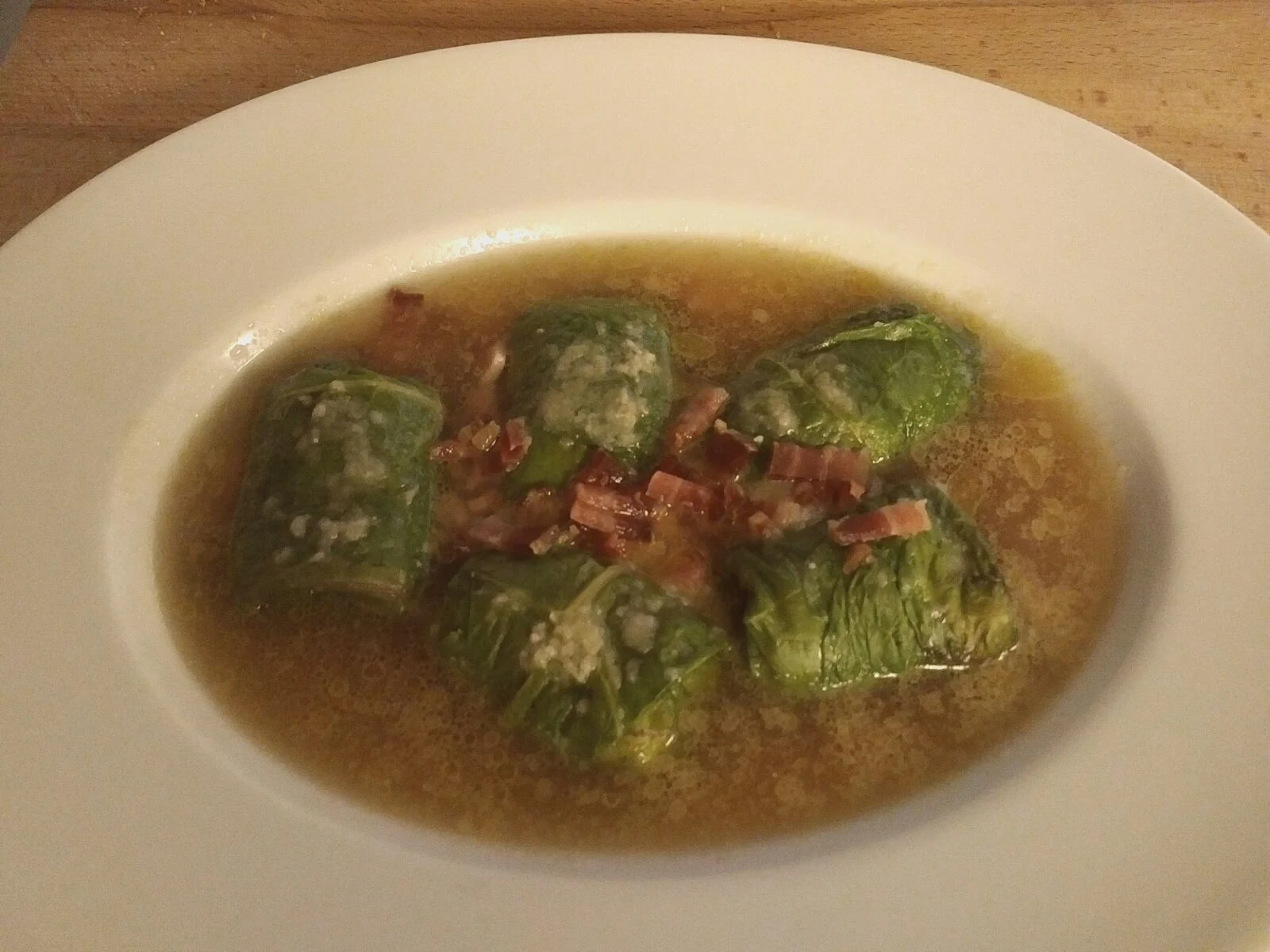 Capuns ze Graubündenu s slaninou a vývarem na talíři.