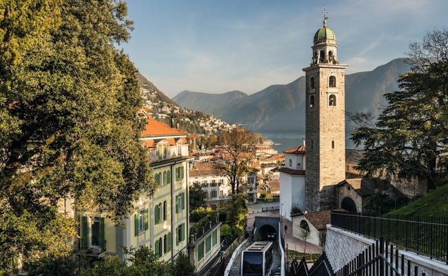 Sankt Lorenzo-katedralen i Lugano med berg och stadsutsikt.