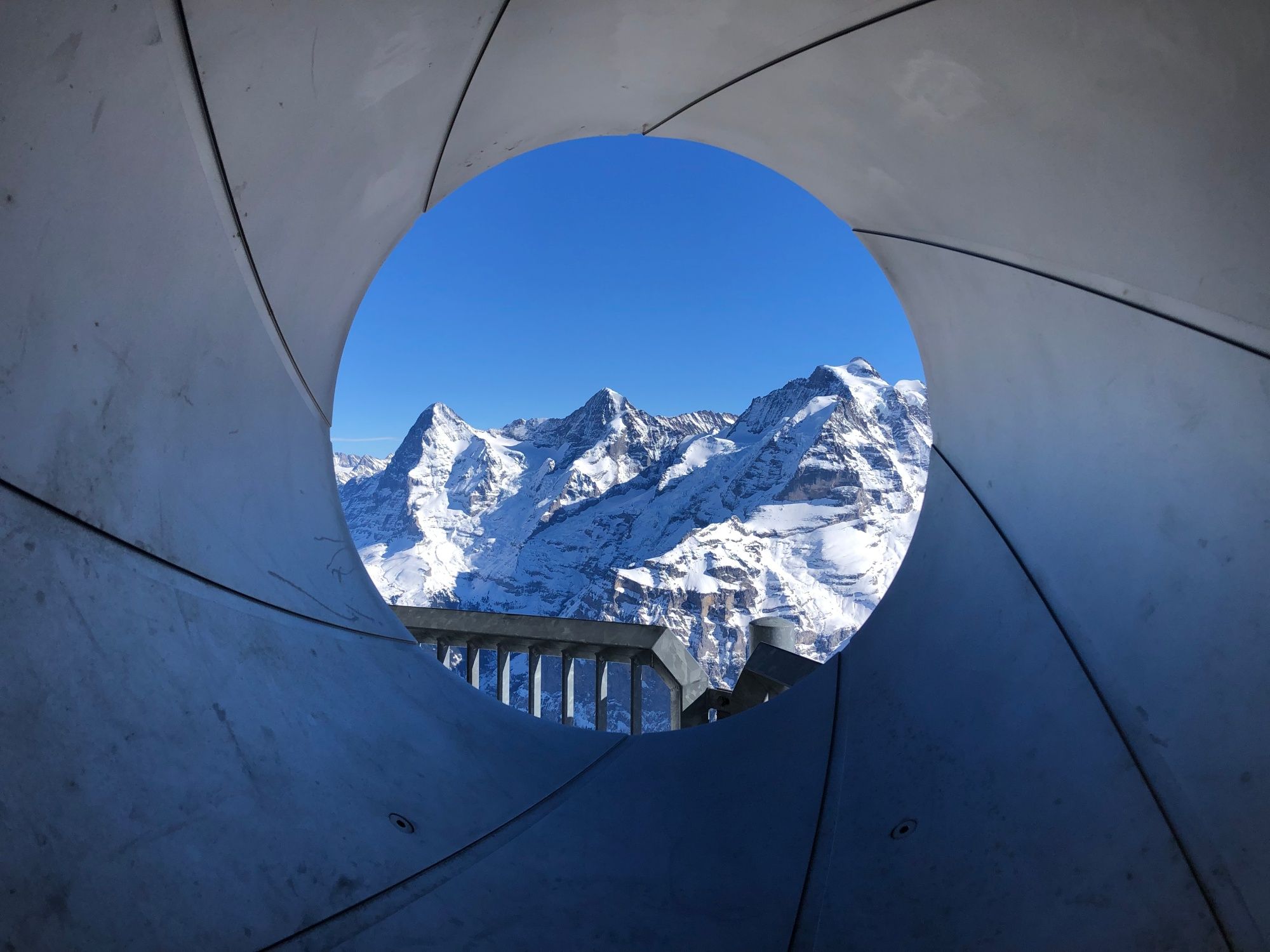 การวางแผนการเดินทางไปชมวิวที่ชิลท์ฮอร์นพร้อมทิวทัศน์ของภูเขาที่ปกคลุมด้วยหิมะและท้องฟ้าสีฟ้า