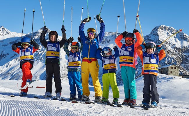 Escuela de Esquí Arosa: Niños con esquís se alegran en la nieve.
