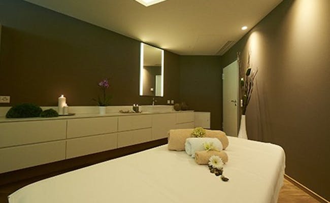 Masážní místnost s masážním stolečkem, ručníky a relaxační atmosférou.