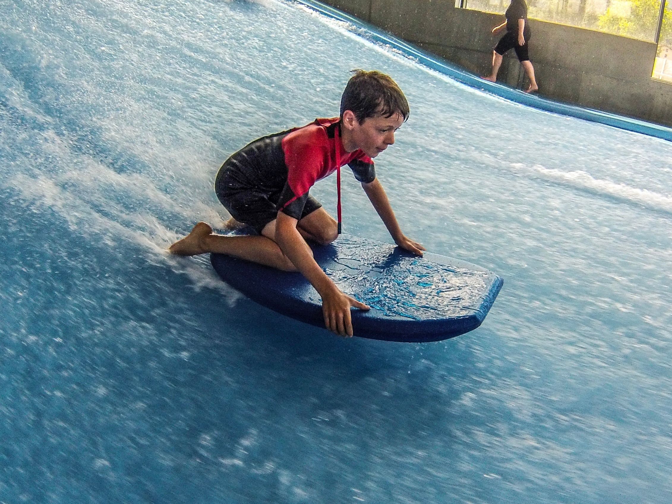Bodyboarding: Boy surfs on a bodyboard in the Xstream Park water having a lot of fun