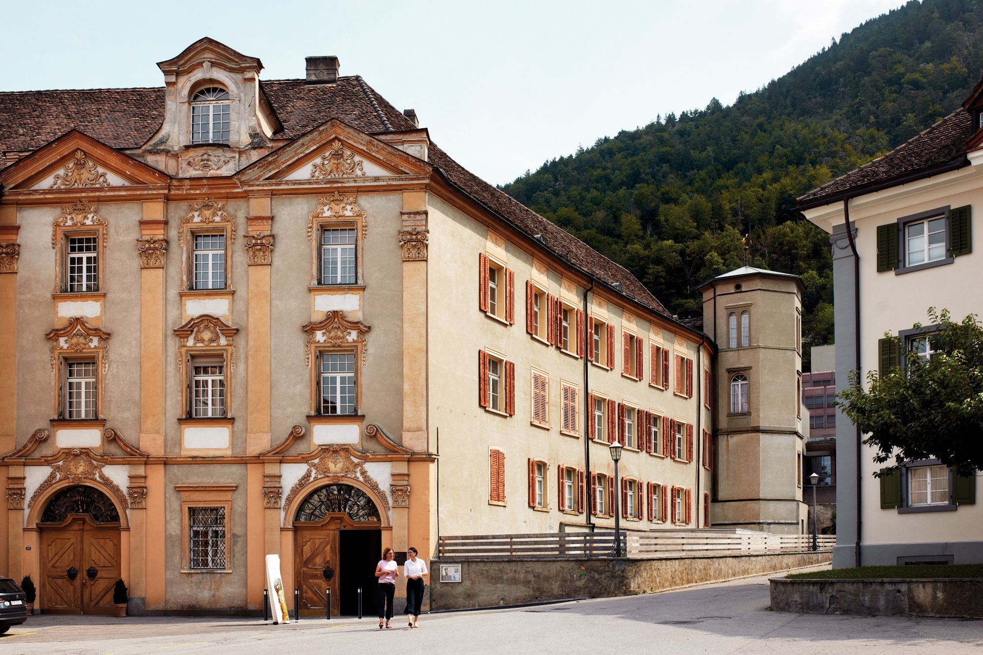 Domkirkesamlingen i Chur med historisk bygning, solrig dag, omgivelser med bjerge.