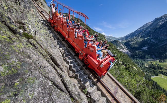 Kolejka Gelmerbahn w Grimselwelt, osoby jadące w dół przez alpejski krajobraz
