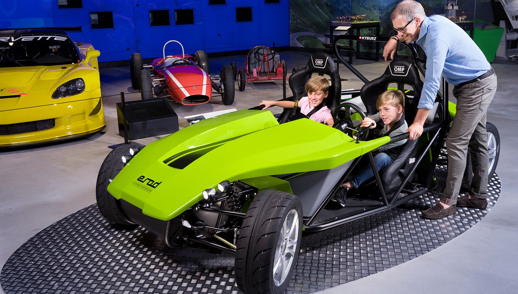 लूसर्न ट्रैफिक म्यूज़ियम में बच्चे रेस कार में चल रहे हैं