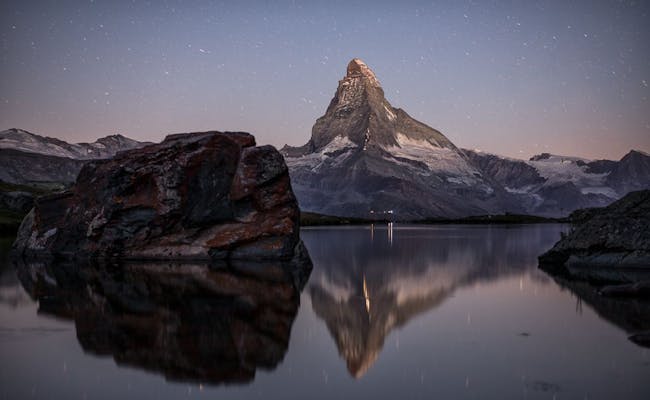 Stellisee: O céu estrelado reflete-se no lago com o Matterhorn ao fundo em Zermatt.