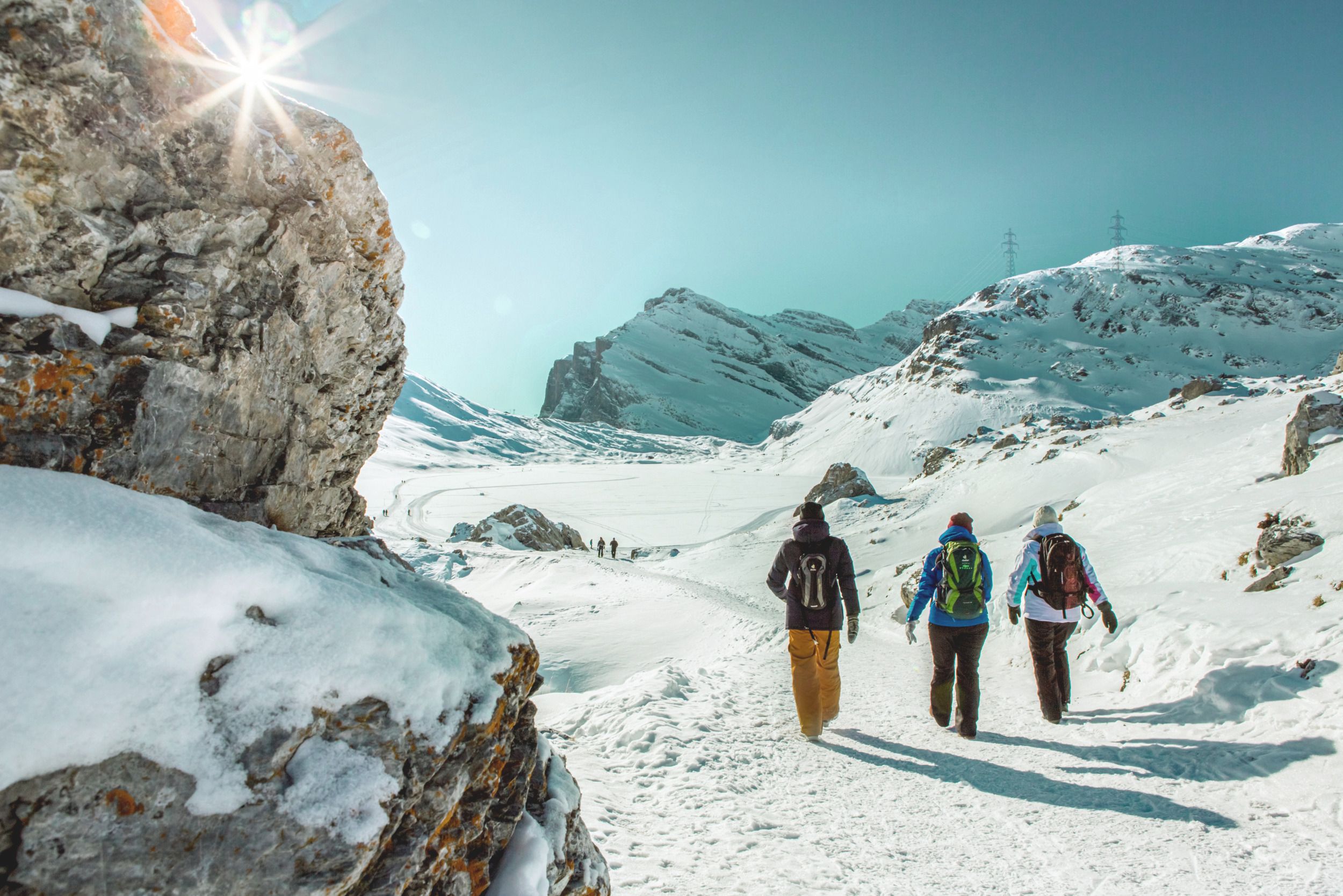 Gemmi Winter: Winterwandelen in een dromerige berglandschap met sneeuw en heldere lucht.