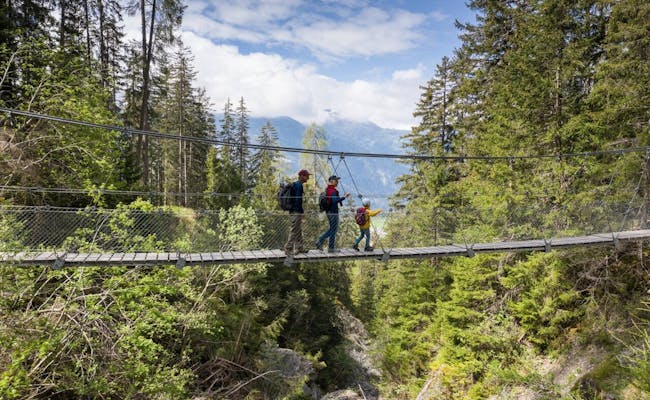 Val Meltger hangbrug met wandelaars in Lenzerheide, bos, frisse lucht.