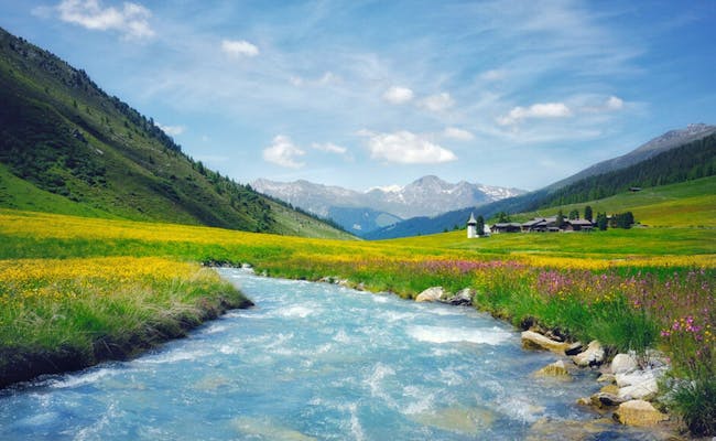 Sertig Bach mit blühenden Wiesen und Bergen