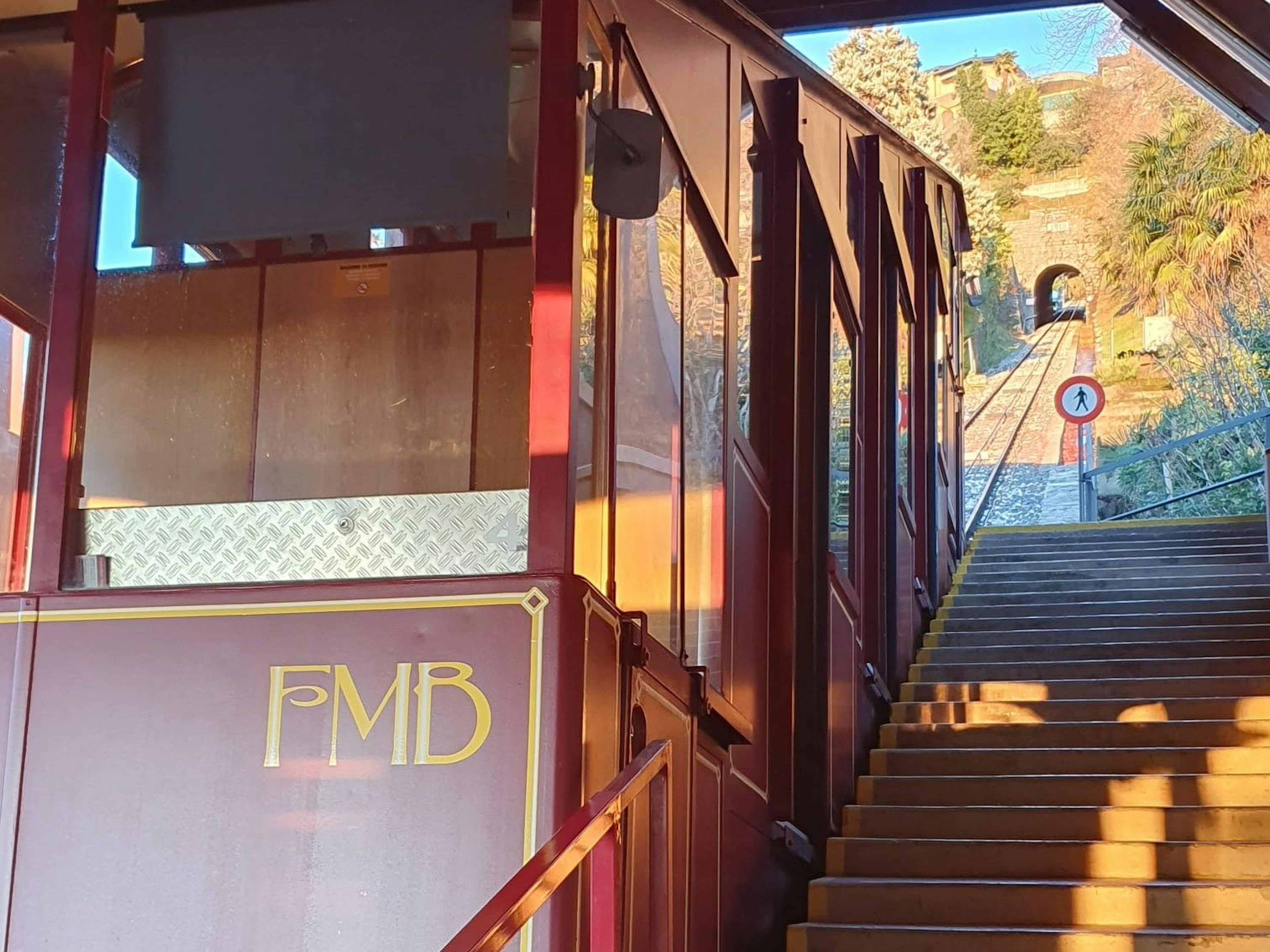 Monte Bre Bahn: Schöne Aussicht auf die Berglandschaft mit Seilbahn und Treppe.