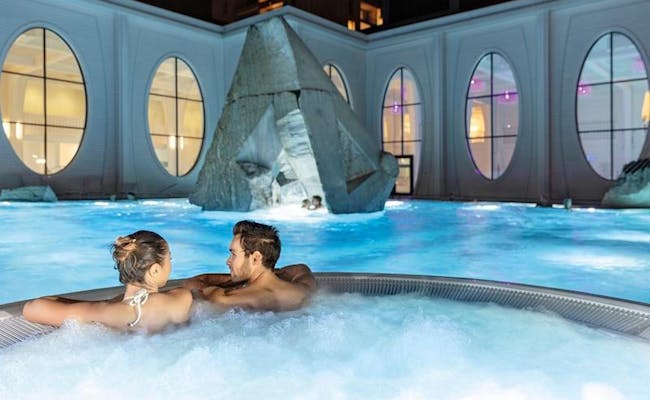 Therme Bad Ragaz con pareja en hidromasaje, relajante, superficie de agua azul, ambiente relajado.