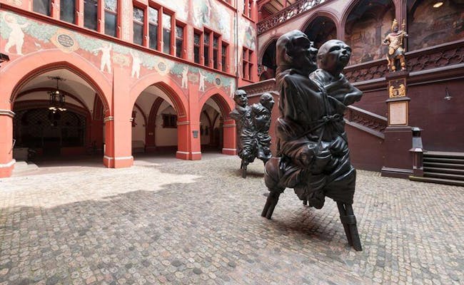 Ratusz w Bazylei z zabytkową architekturą i pomnikiem na dziedzińcu.