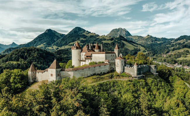 Schloss Gruyere: beeindruckende Burg umgeben von malerischer Natur und Hügeln in der Schweiz.