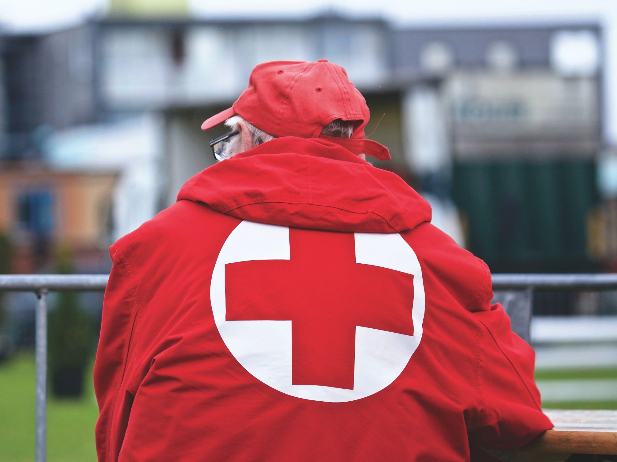 赤い十字のマントを着た人がフェスティバルを観察している