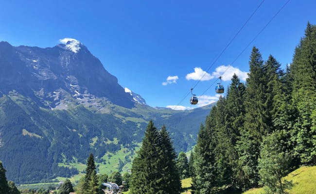 Grindelwald First teleférico com vista para as montanhas, ideal para atividades de verão na natureza.