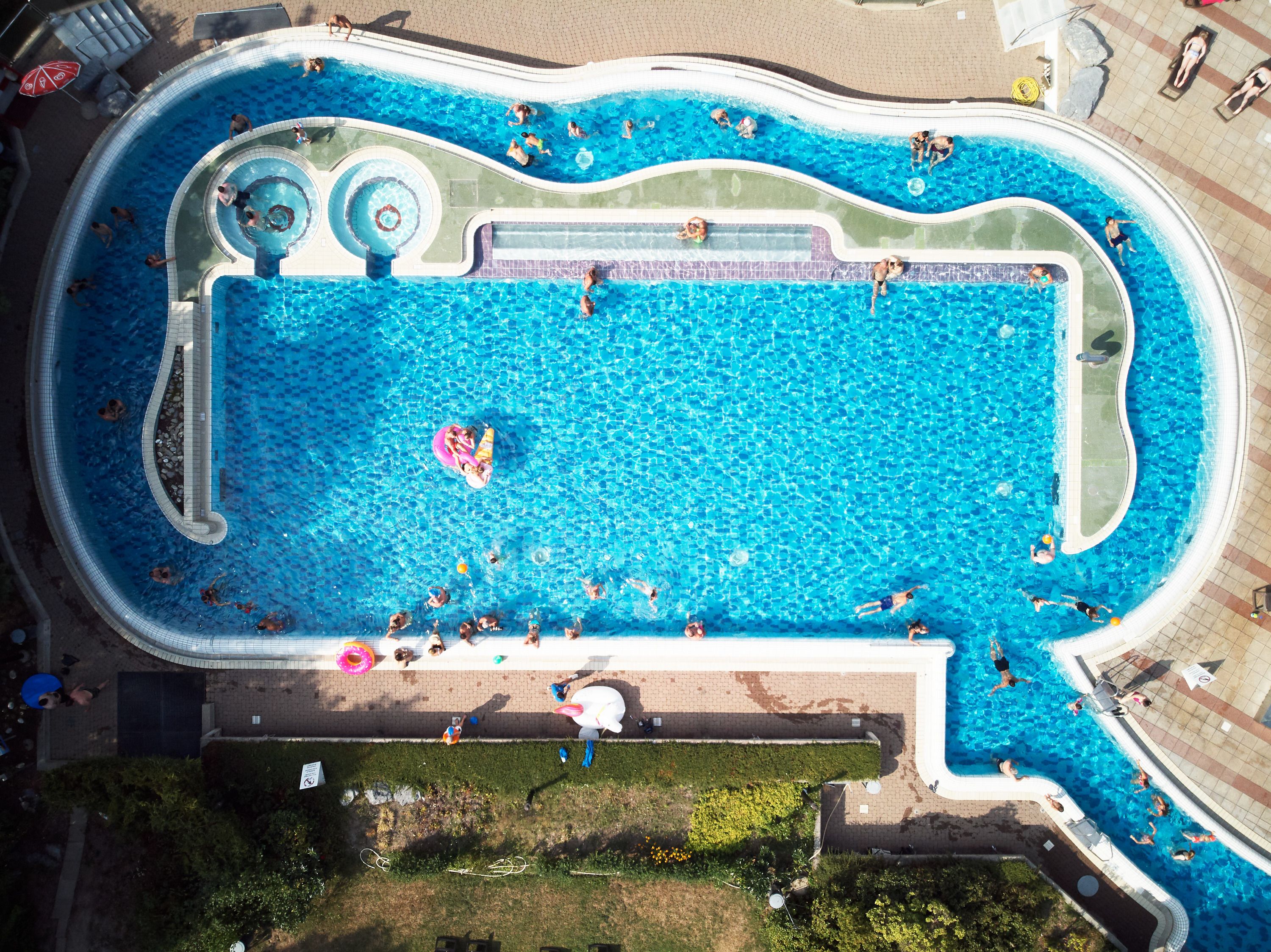 अल्पामारे जलरॉपणाक और बाहरी स्वीमिंग पूल में दर्शकों के साथ धूप वाला दिन।